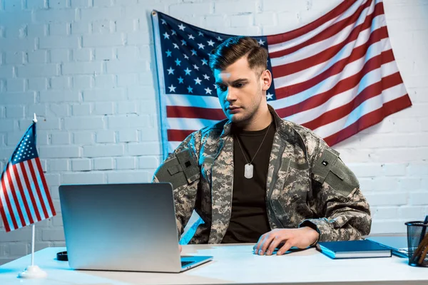 Handsome soldier in uniform using laptop in office — Stock Photo