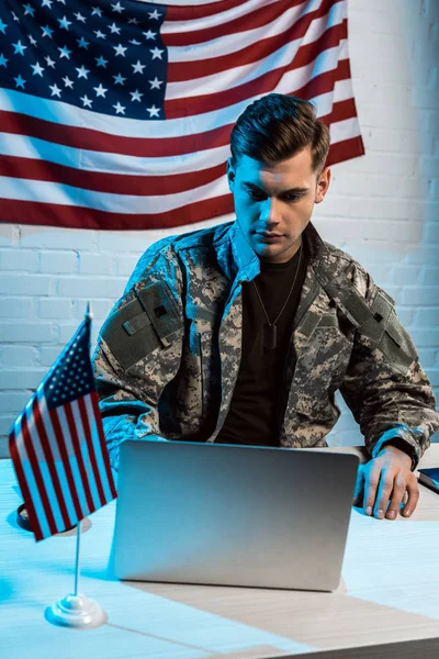 Schöner Soldat in Uniform sitzt im Büro und benutzt Laptop — Stockfoto