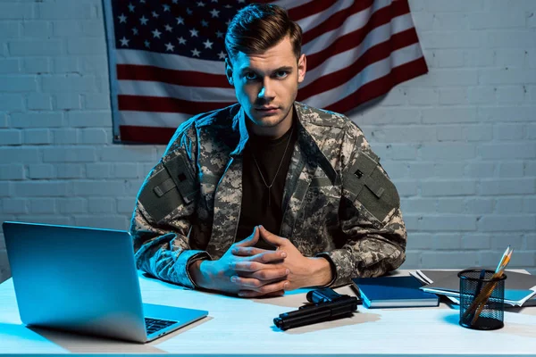 Красивий військовий чоловік у формі сидить в офісі і дивиться на камеру — стокове фото