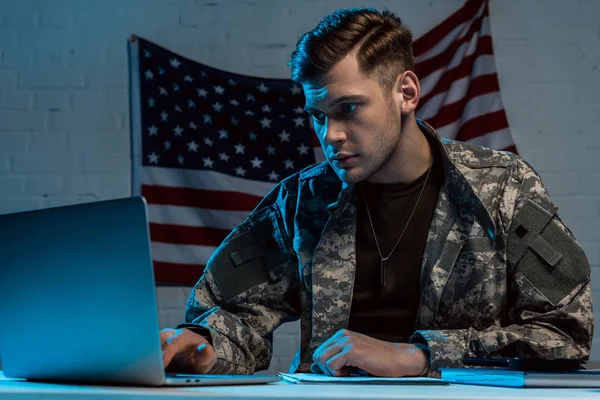 Beau soldat en uniforme militaire à l'aide d'un ordinateur portable au bureau — Photo de stock