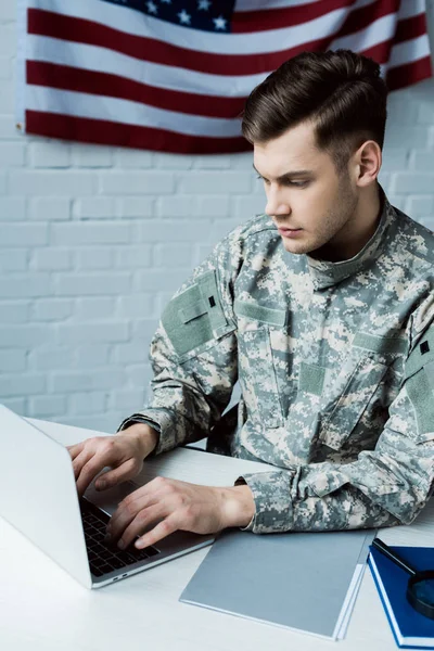 Young military man using laptop in modern office — Stock Photo