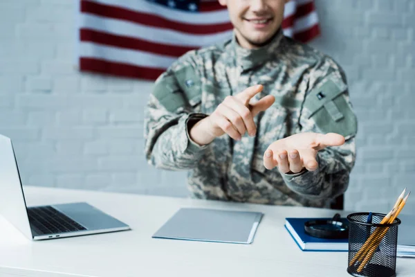 Vista cortada de homem feliz em uniforme militar apontando com o dedo no escritório — Fotografia de Stock