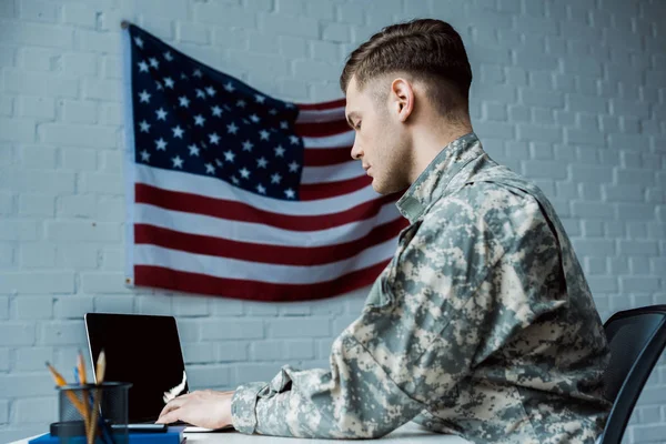 Visão de ângulo baixo de soldado bonito usando laptop com tela em branco — Fotografia de Stock