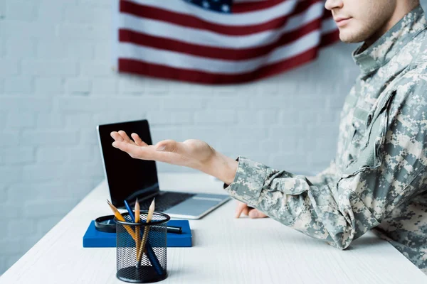Vue recadrée du soldat gesticulant près d'un ordinateur portable avec écran vide — Photo de stock