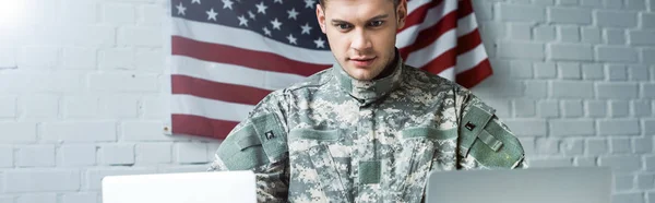 Panoramic shot of handsome soldier using laptops in office — Stock Photo