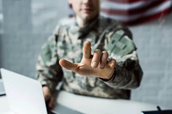 Enfoque selectivo del hombre en uniforme de camuflaje apuntando con el dedo - foto de stock