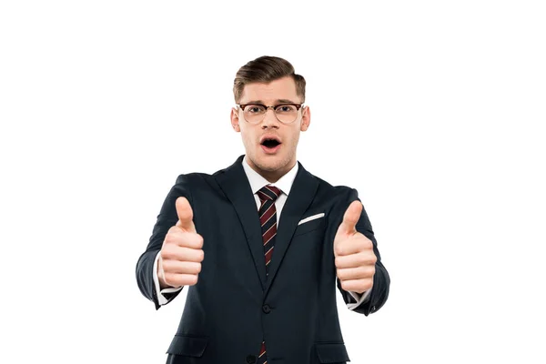 Sorprendido hombre de negocios en gafas mostrando pulgares hacia arriba aislado en blanco - foto de stock