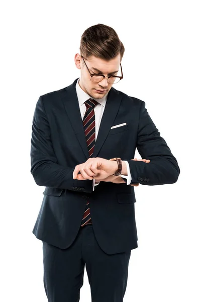 Bello uomo d'affari in occhiali guardando orologio isolato su bianco — Foto stock