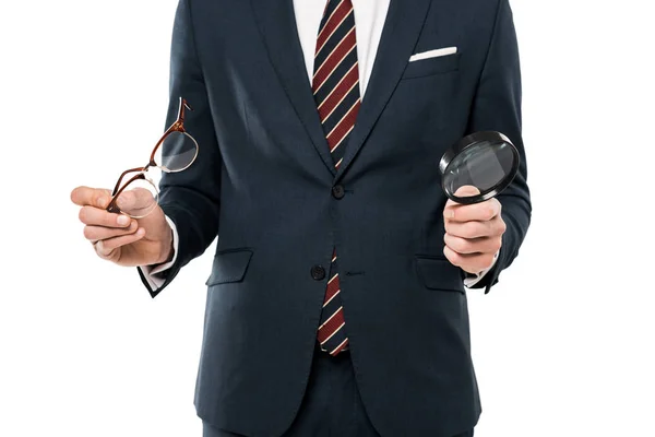 Vista recortada de hombre de negocios sosteniendo gafas y lupa aislada en blanco - foto de stock