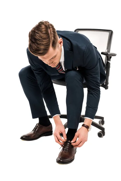 Schöner Geschäftsmann im Anzug, der Schnürsenkel auf Weiß bindet — Stockfoto