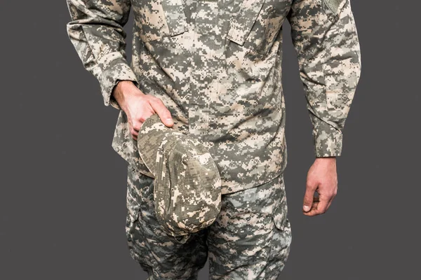 Cropped view of soldier holding cap isolated on grey — Stock Photo