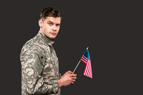 Hombre de uniforme militar con bandera americana aislada en gris - foto de stock
