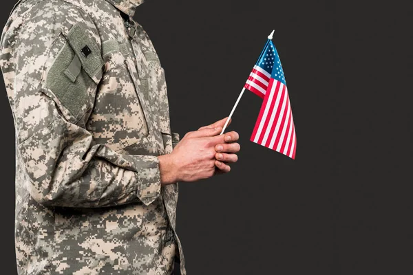 Vista cortada de soldado segurando bandeira americana isolado em cinza — Fotografia de Stock
