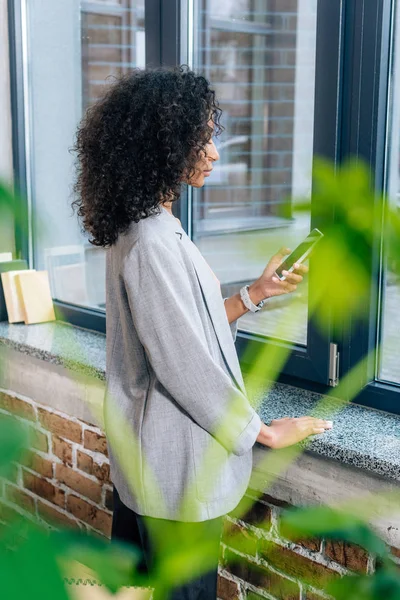 Selektiver Fokus der afrikanisch-amerikanischen Gelegenheitsunternehmerin mit Smartphone — Stockfoto