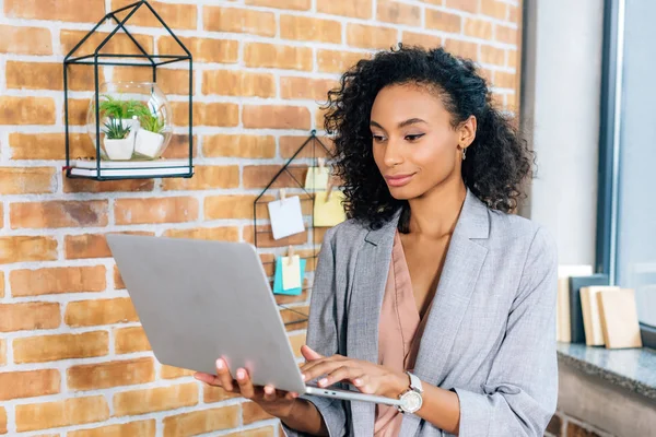 Beautiful african american Casual businesswoman using laptop in loft office — Stock Photo