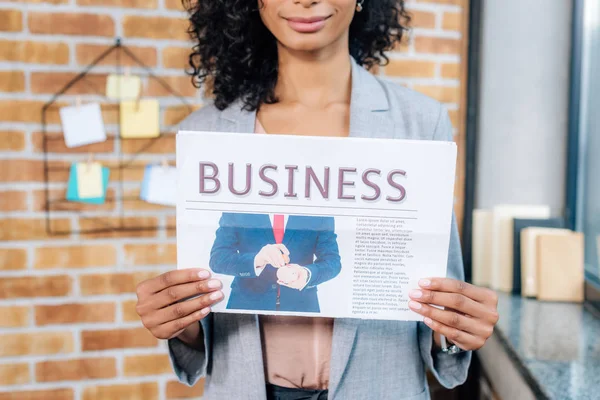 Cropped view of african american Casual businesswoman holding business newspaper in loft office — Stock Photo