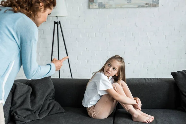 Selektiver Fokus des Kindes auf die Mutter, die zu Hause mit dem Finger zeigt — Stockfoto