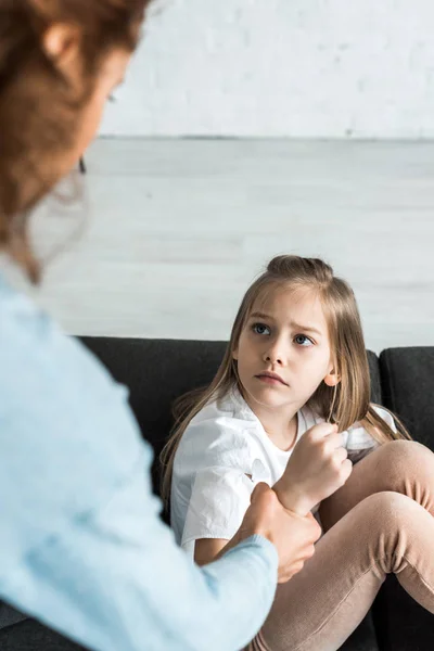 Selective focus of scared kid looking at mother at home — Stock Photo