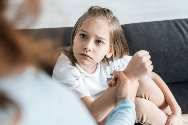 Selektiver Fokus verängstigter Kinder auf Mutter, die sich zu Hause an der Hand hält — Stockfoto