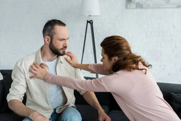 Angry woman pushing handsome bearded man at home — Stock Photo