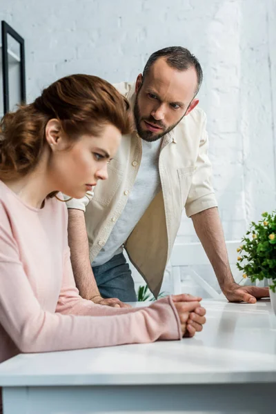 Selective focus of man looking at offended brunette woman — Stock Photo