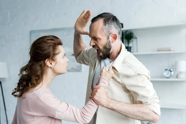 Hombre enojado gesto amenazando y mirando a la mujer atractiva - foto de stock