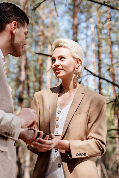 Красива і усміхнена жінка приймає пропозицію шлюбу в лісі — стокове фото