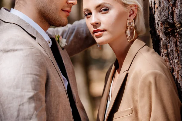 Stilvolles Paar in braunen Jacken steht im Wald — Stockfoto