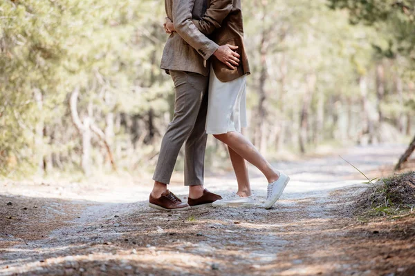 Vista cortada de casal elegante abraçando na floresta — Fotografia de Stock