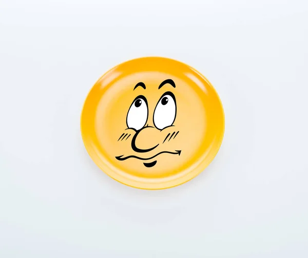 Vista superior da placa amarela brilhante com sorriso triste no fundo branco — Fotografia de Stock