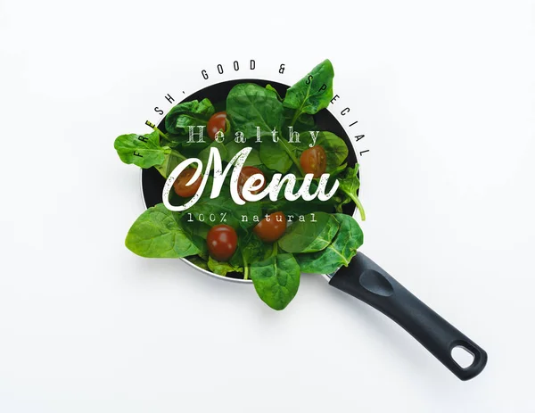 Fresh spinach leaves and cherry tomatoes in frying pan with healthy menu lettering on white background — Stock Photo