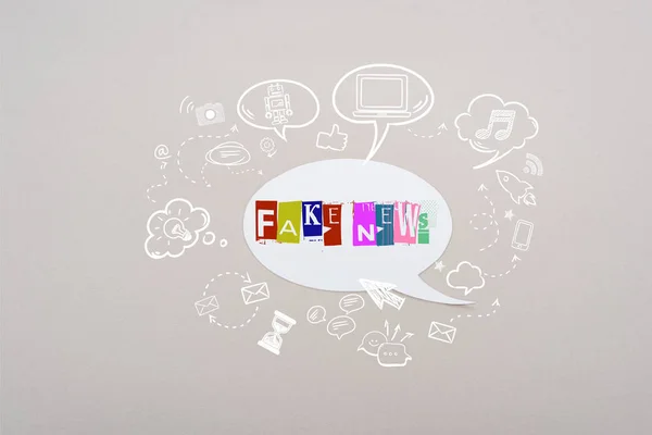 Burbuja de habla blanca con letras de noticias falsas e ilustración de redes sociales sobre fondo gris - foto de stock