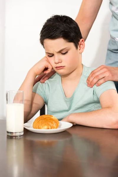 Обрезанный вид отца и расстроенный сын во время завтрака — стоковое фото