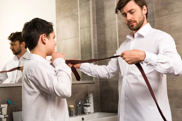 Father and son dressing in formal wear in bathroom — Stock Photo