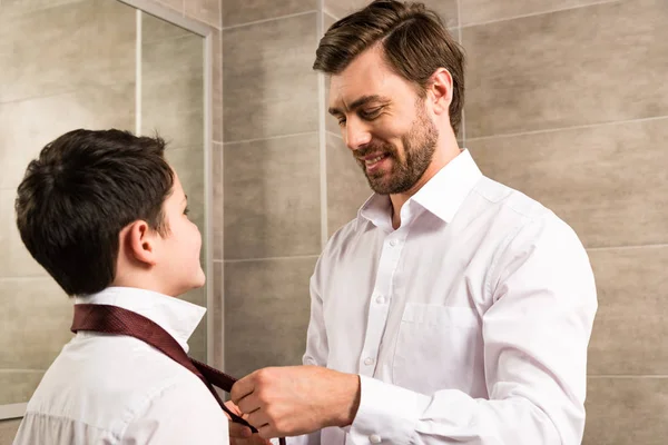 Father and son dressing in formal wear in bathroom — Stock Photo