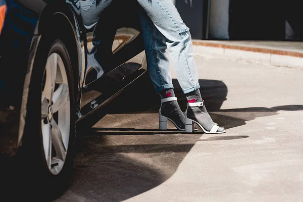 Vue recadrée de la jeune femme à la mode posant près de la voiture — Photo de stock