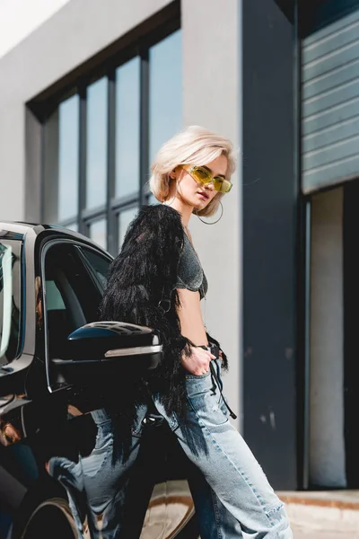 Bella moda giovane donna sexy in occhiali posa vicino auto — Foto stock
