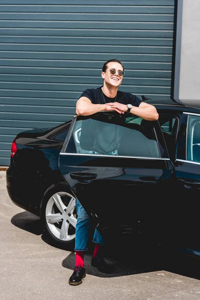 Bonito elegante homem sorrindo e posando perto do carro — Fotografia de Stock