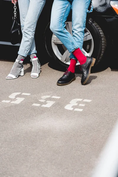 Cropped view of stylish man and girl in denim posing near car — Stock Photo