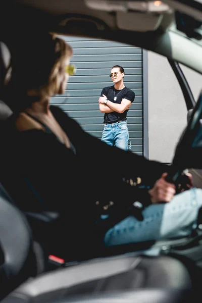 Foco seletivo de homem elegante olhando para a menina sentada no carro — Fotografia de Stock