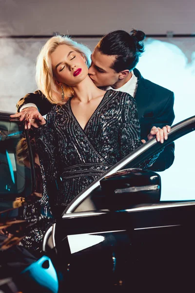 Homem elegante beijando bela mulher sensual perto do carro — Fotografia de Stock