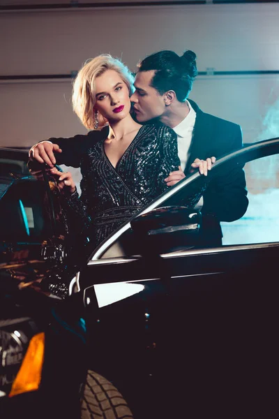Stylish man kissing beautiful sensual woman near car — Stock Photo