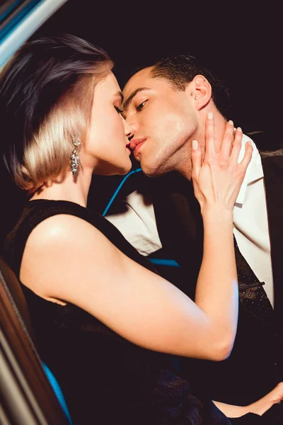 Beautiful fashionable young woman kissing handsome man — Stock Photo