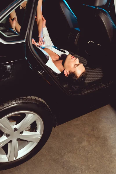 Giovane donna spogliarsi bello uomo in auto — Foto stock