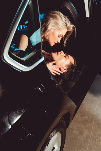 Bel homme et attrayant jeune femme embrassant dans la voiture — Stock Photo