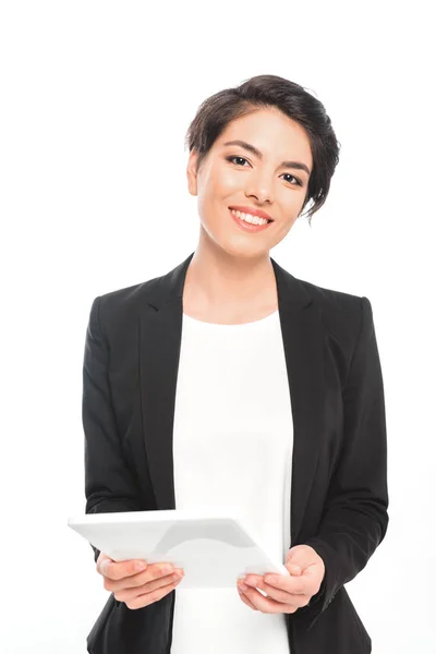 Atractiva mujer de negocios de raza mixta sosteniendo tableta digital mientras mira la cámara aislada en blanco - foto de stock