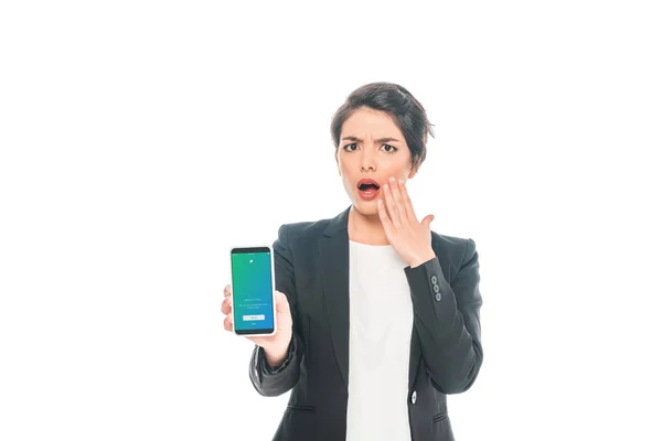 KYIV, UKRAINE - APRIL 24, 2019: Shocked mixed race businesswoman holding smartphone with Twitter app on screen isolated on white. — Stock Photo