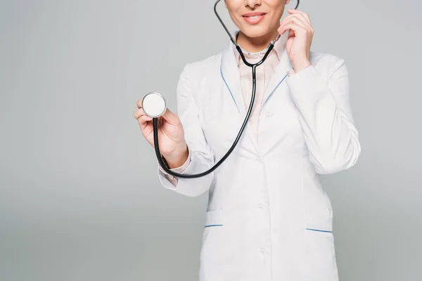 Обрізаний знімок змішаного гоночного лікаря з використанням стетоскопа ізольовано на сірому — стокове фото
