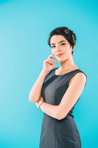 Beautiful mixed race woman posing at camera with hand near face isolated on blue — Stock Photo