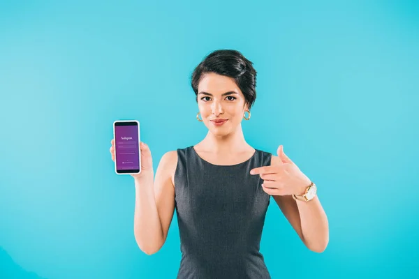 KYIV, UKRAINE - APRIL 24, 2019: Smiling mixed race woman showing smartphone with Instagram app on screen isolated on blue. — Stock Photo